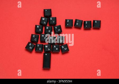 Christmas tree made of black computer keys on red background Stock Photo
