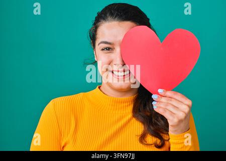 Smiling Young Woman Holding Red Paper Heart Over One Eye Portrait For Valentine Love Concept Stock Photo