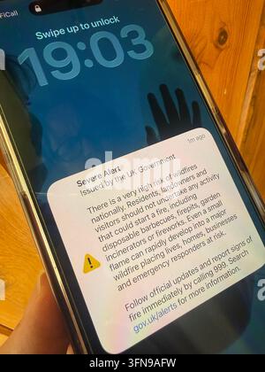 Smart phone, screen showing Severe Alert issued by the UK Government to warn of a very high risk of wildfires during the drought and heatwaves Stock Photo