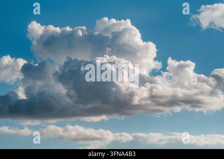 View of fluffy white cumulus clouds drifting across a vibrant blue sky over the city in Novi Sad, Vojvodina, Serbia. Stock Photo