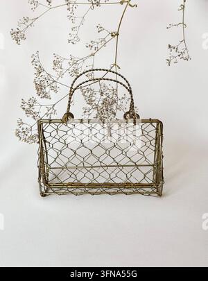 Gold Vintage Handbag Framed by Delicate Baby's Breath Branches on a Light Neutral Background with Copy Space Stock Photo