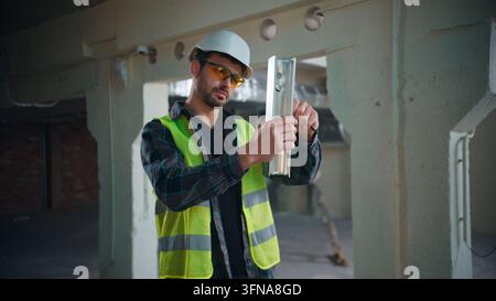 Caucasian architect man repairing metal component with tool construction work male engineer builder guy handyman technician fixing iron fitting Stock Photo