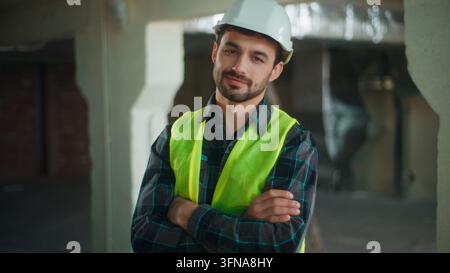 Cheerful Caucasian builder man smiling looking camera at construction site glad confident male worker posing contractor in helmet engineer Stock Photo