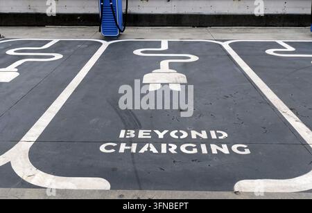Electric vehicle parking spot showing a plug icon and beyond charging text, representing sustainable energy solutions and the future of transportation Stock Photo