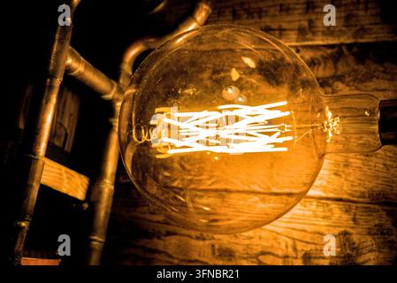 Vintage Edison Filament Light Bulb Glowing in Dark Loft Interior  Stock Photo