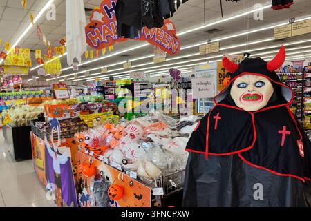 Bangkok, Thailand - September. 21, 2026 : Spooky Halloween merchandise and decorations including masks, pumpkin buckets, and a devil costume displayed Stock Photo