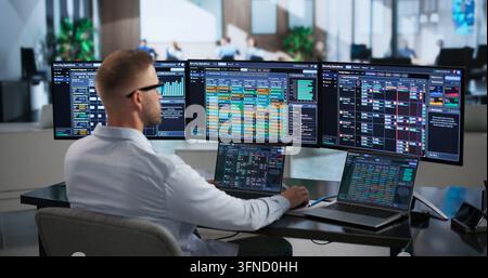 Cybersecurity Analyst Carefully Monitors Threat Alerts On Laptop In Busy Center. Stock Photo