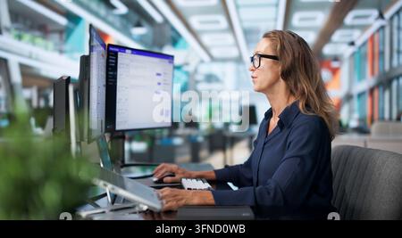Customer Support Specialist Efficiently Manages AI Chatbot Software On Laptop. Stock Photo