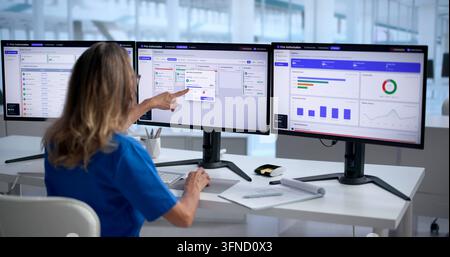 Healthcare Manager Carefully Reviews Medical Claims Using Electronic Dashboard System. Stock Photo