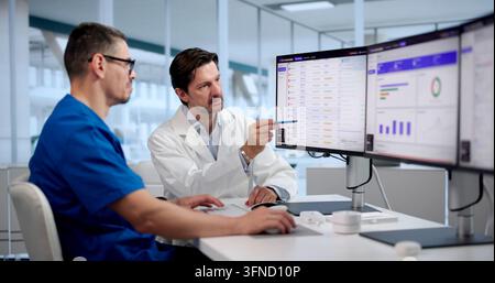 Healthcare Manager Carefully Reviews Electronic Medical Claims Using Software Dashboard. Stock Photo
