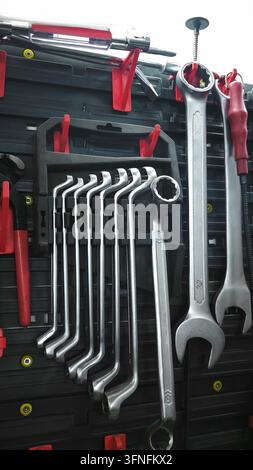 set of wrenches organized neatly on wall rack. Various sizes of tools displayed in professional workshop setup, perfect for repair and maintenance tas Stock Photo