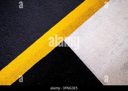 London, UK, October 03 2026, Abstract Geometric Car Park Floor Paint Markings Featuring Bold Yellow, White And Black Lines Stock Photo