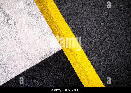 London, UK, October 03 2026, Abstract Geometric Car Park Floor Paint Markings Featuring Bold Yellow, White And Black Lines Stock Photo