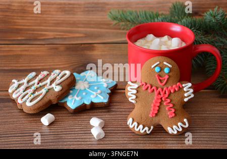 Gingerbread Man and Christmas Cookies with Hot Cocoa in a red mug on Wooden Table Stock Photo