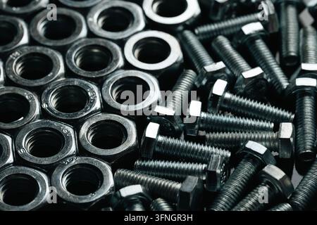 Metal bolts and nuts forming an industrial fasteners background Stock Photo