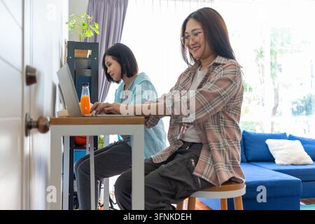 Work from Home: Two women engrossed in remote work, their focused expressions mirroring the productivity and flexibility of a modern, adaptable workpl Stock Photo