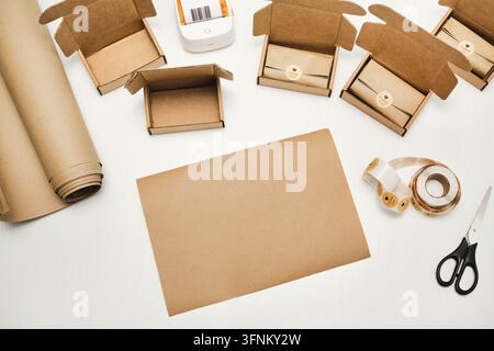 Packaging supplies and cardboard boxes with products and thank you stickers on white table Stock Photo