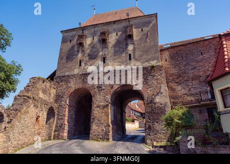 Medieval fortified gateway with twin arches and massive stone walls in Sighisoara Romania Stock Photo
