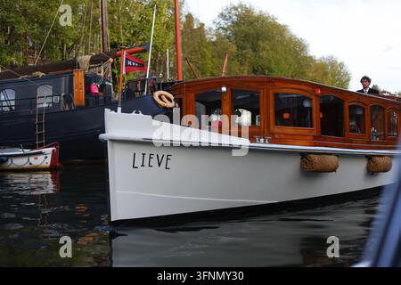 Amsterdam, Netherlands - October 1, 2026: Lieve passenger boat with a polished wooden cabin cruises along a city canal. Stock Photo