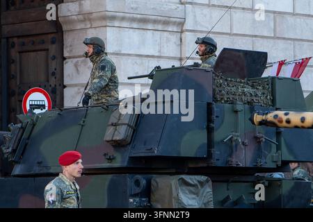 Vienna, Austria, 26 Oktober 2025, Soldiers stand on an armored vehicle in a public street scene near a building. Stock Photo
