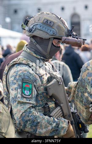 VIENNA, AUSTRIA, 26 oktober 2025: A camouflaged soldier stands in profile wearing tactical gear and a mounted night vision device. Stock Photo
