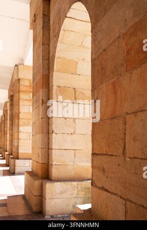 A repetitive perspective of classic architectural colonnade or arcade constructed from rectangular natural sandstone blocks Stock Photo
