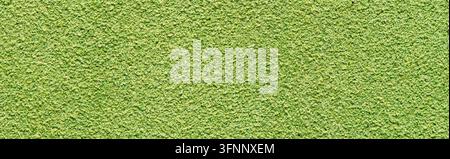 Detailed macro shot of a bright green suede leather surface featuring a velvety nap texture and soft tactile appearance with warm ambient lighting. Stock Photo