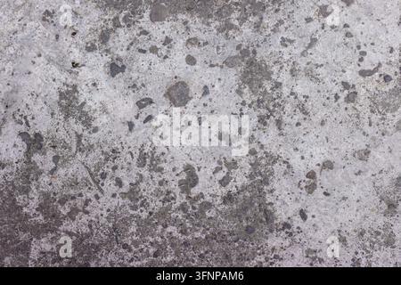 Full frame shot of an aged concrete surface featuring dark stain spots, coarse stone aggregates, and weathered cement details for background use. High Quality Photo Stock Photo