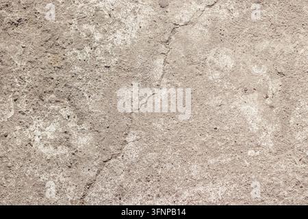 Close up view of a light gray weathered concrete floor showing a vertical hairline crack, fine grain texture, and subtle white dust marks ideal for design work. High Quality Photo Stock Photo