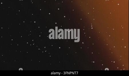A grainy, dark night sky filled with small white stars, illuminated by a warm orange light gradient on the upper right side. Stock Photo