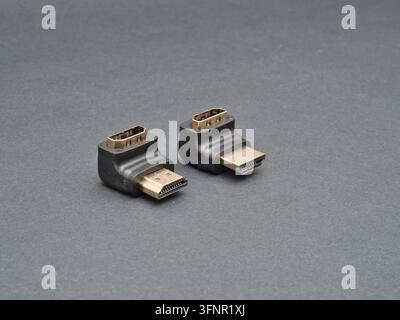 Two HDMI Adapters on Gray Background - Pair of black HDMI male-to-male adapters with gold-plated connectors shown on a neutral dark gray background, i Stock Photo