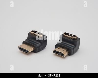 Two Black HDMI Right Angle Adapters - Two L-shaped HDMI male to female adapters in black plastic and gold-plated connectors, on a clean white backgrou Stock Photo