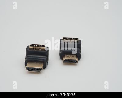 Two Black HDMI Right Angle Adapters - Two L-shaped HDMI male to female adapters in black plastic and gold-plated connectors, on a clean white backgrou Stock Photo