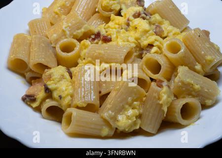 Rigatoni alla carbonara is an undisputed pillar of Roman cuisine. To achieve that perfect, creamy sauce without the "omelet" effect the secret lies en Stock Photo