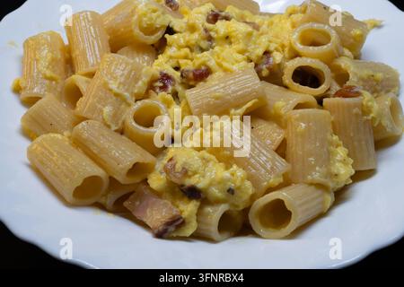 Rigatoni alla carbonara is an undisputed pillar of Roman cuisine. To achieve that perfect, creamy sauce without the "omelet" effect the secret lies en Stock Photo