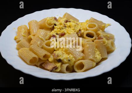 Rigatoni alla carbonara is an undisputed pillar of Roman cuisine. To achieve that perfect, creamy sauce without the "omelet" effect the secret lies en Stock Photo