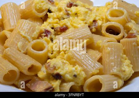 Rigatoni alla carbonara is an undisputed pillar of Roman cuisine. To achieve that perfect, creamy sauce without the "omelet" effect the secret lies en Stock Photo