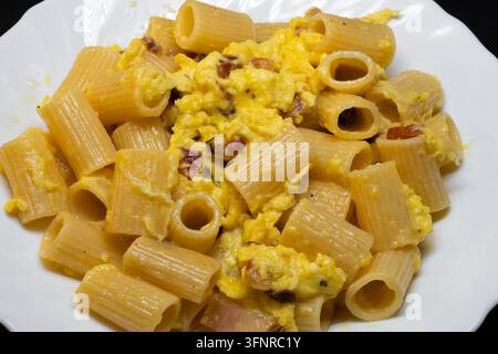 Rigatoni alla carbonara is an undisputed pillar of Roman cuisine. To achieve that perfect, creamy sauce without the "omelet" effect the secret lies en Stock Photo