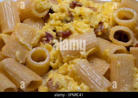 Rigatoni alla carbonara is an undisputed pillar of Roman cuisine. To achieve that perfect, creamy sauce without the "omelet" effect the secret lies en Stock Photo