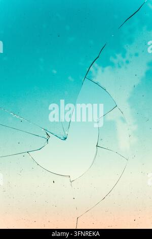 A cracked glass surface with shattered texture and reflective fragments ...
