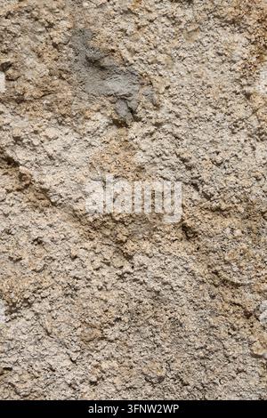 Rough Beige Stucco Wall Texture with Weathered Plaster Surface and Natural Stone Grain. Stock Photo
