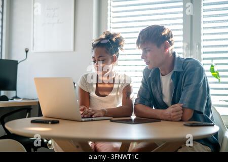 University students working together on laptop during study session. Stock Photo