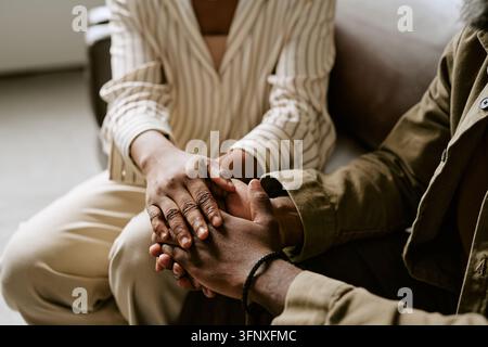 Black Woman Holding Hands of Man during Therapy Session Stock Photo