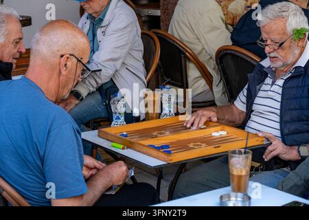 Two senior gentlemen playing a game of Tavli the traditional Greek form of Backgammon at a small cafe (Kafenia) on the island of Zante or Zakynthos. Stock Photo