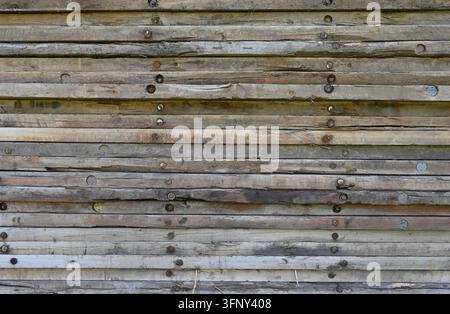 Stacked timber mat sides in a horizontal close-up composition, showing layered wood boards with natural patina and tan tones, Stock Photo