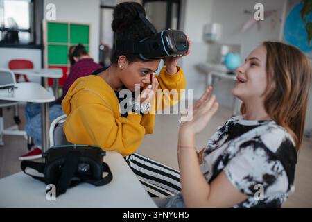 High school student using virtual reality for immersive learning in classroom. Stock Photo