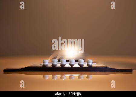 Creative low angle view along the acoustic guitar strings from bridge to headstock, abstract musical instrument perspective. Stock Photo