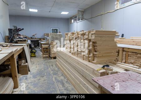 Woodworking workshop interior with stacked lumber and machines Stock Photo