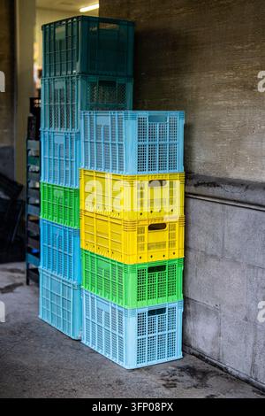Colorful empty bread crates stacked outside store after bakery delivery and product unloading Stock Photo