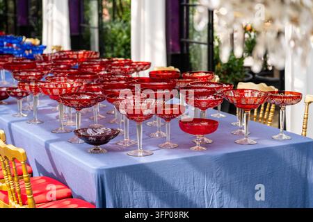 Rows of vintage red crystal glasses prepared on banquet table for elegant festive reception Stock Photo